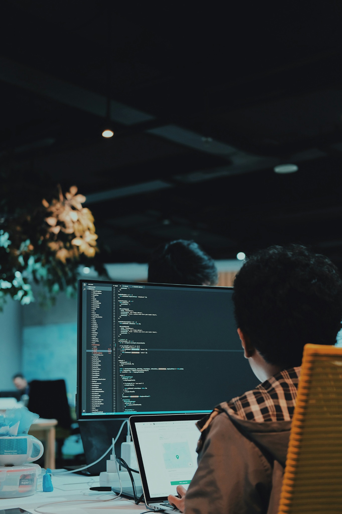 Person working at a computer and coding workstation